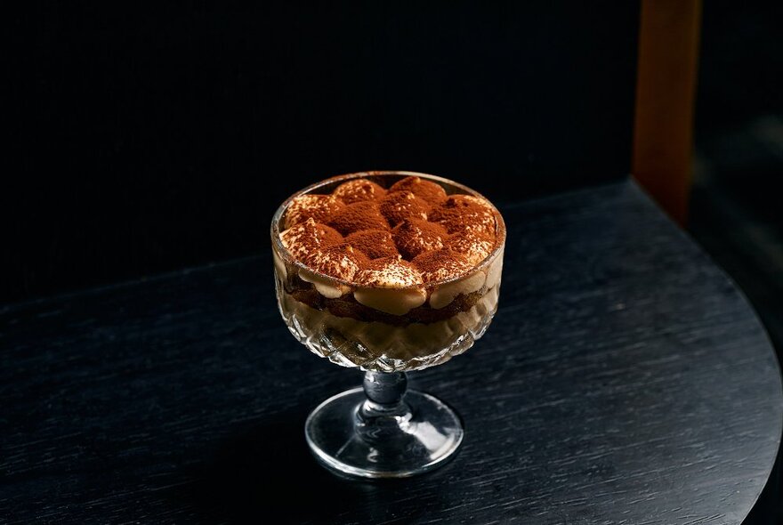 A creamy dessert served in a parfait glass on a table.