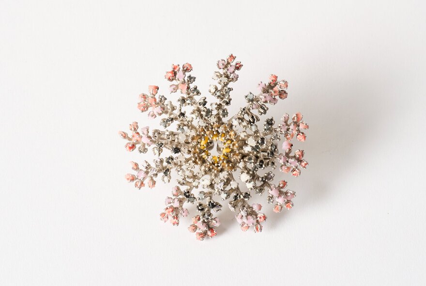 Intricate snowflake-style brooch featuring delicate branching details with pink and clear crystal accents.