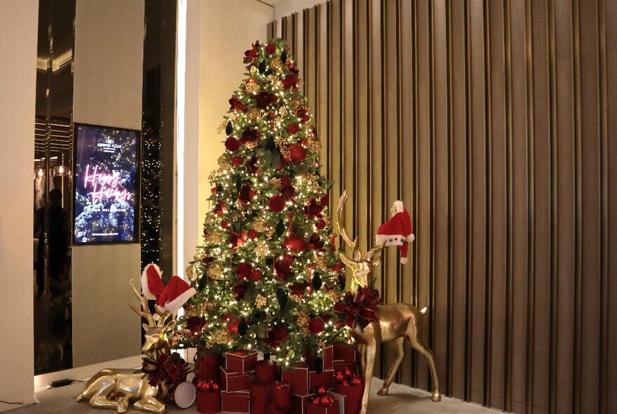 A decorated Christmas tree in the foyer of a hotel.