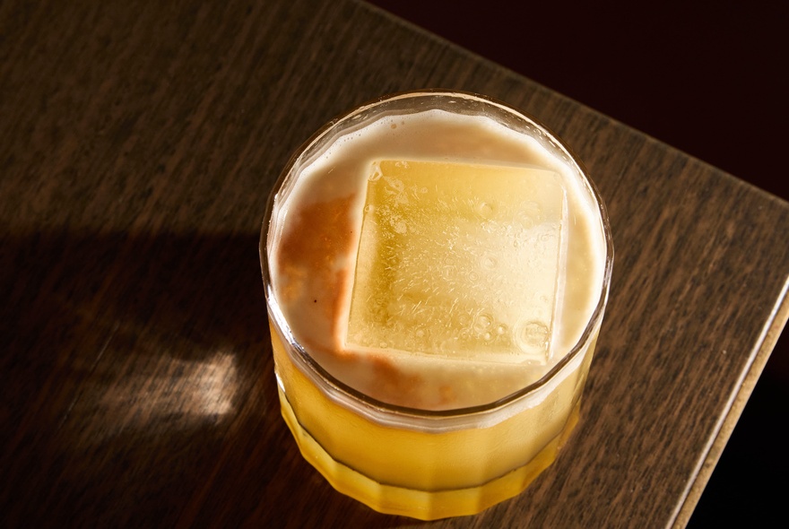 A handcrafted cocktail served in a short, heavy-bottomed rocks glass.