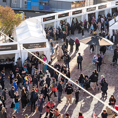 Overhead view of an outdoor market at Fed Square, with people browsing the stalls and walking around.