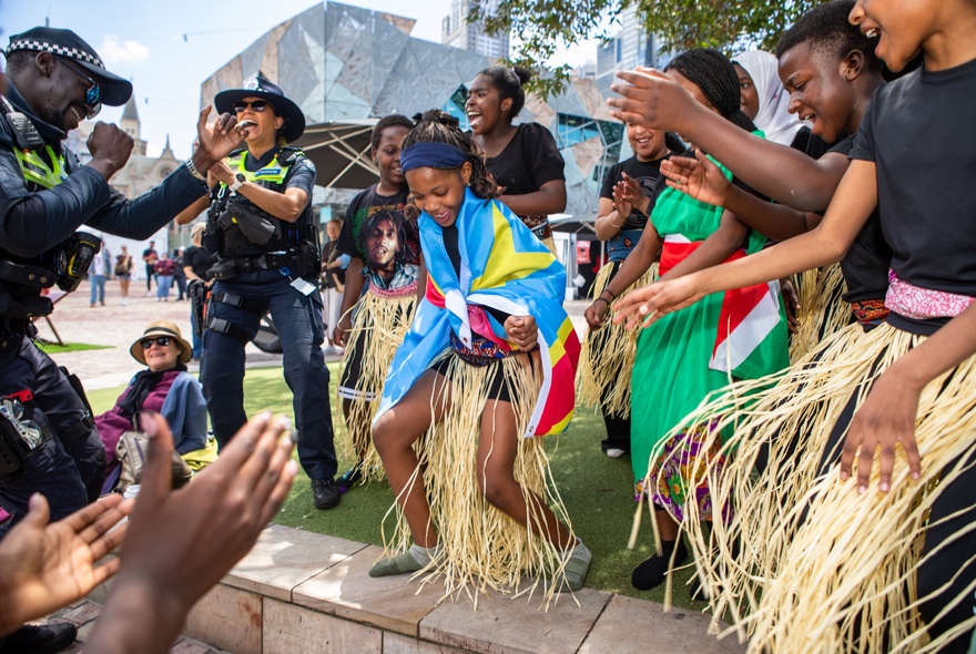 Traditional African dancers wearing grass skirts and colourful shawls.