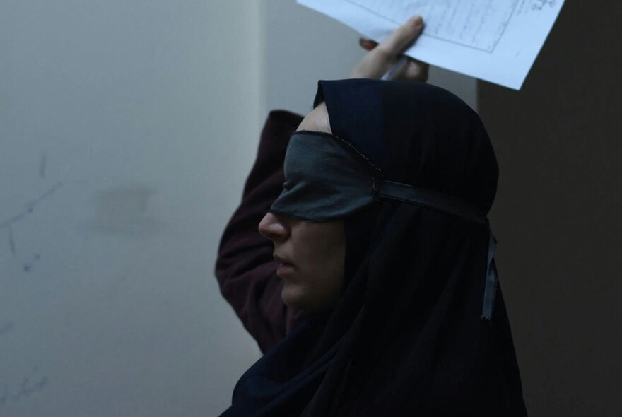 Hand holding the edge of a sheet of paper.