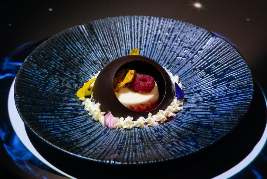 Dark plate with domed dessert in the centre.