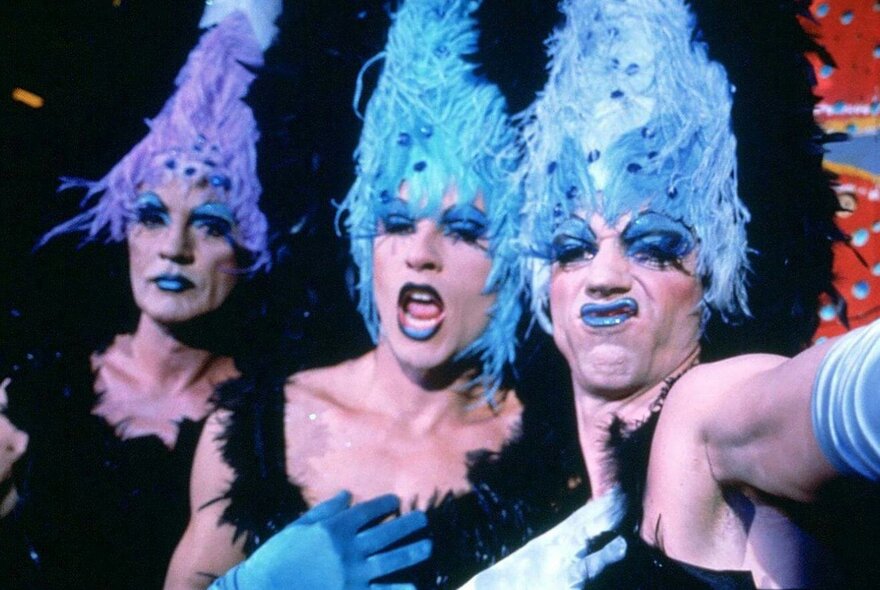 Three actors in character and full drag costumes from the film The Adventures of Priscilla, Queen of the Desert