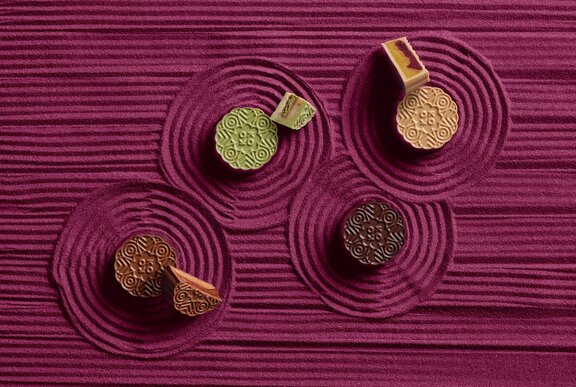 Four different coloured mooncakes.
