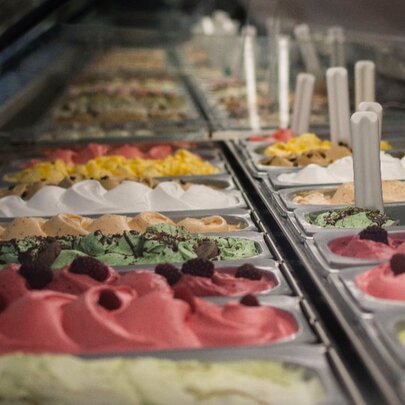 A selection of colourful gelato tubs in a ridge each with toppings.