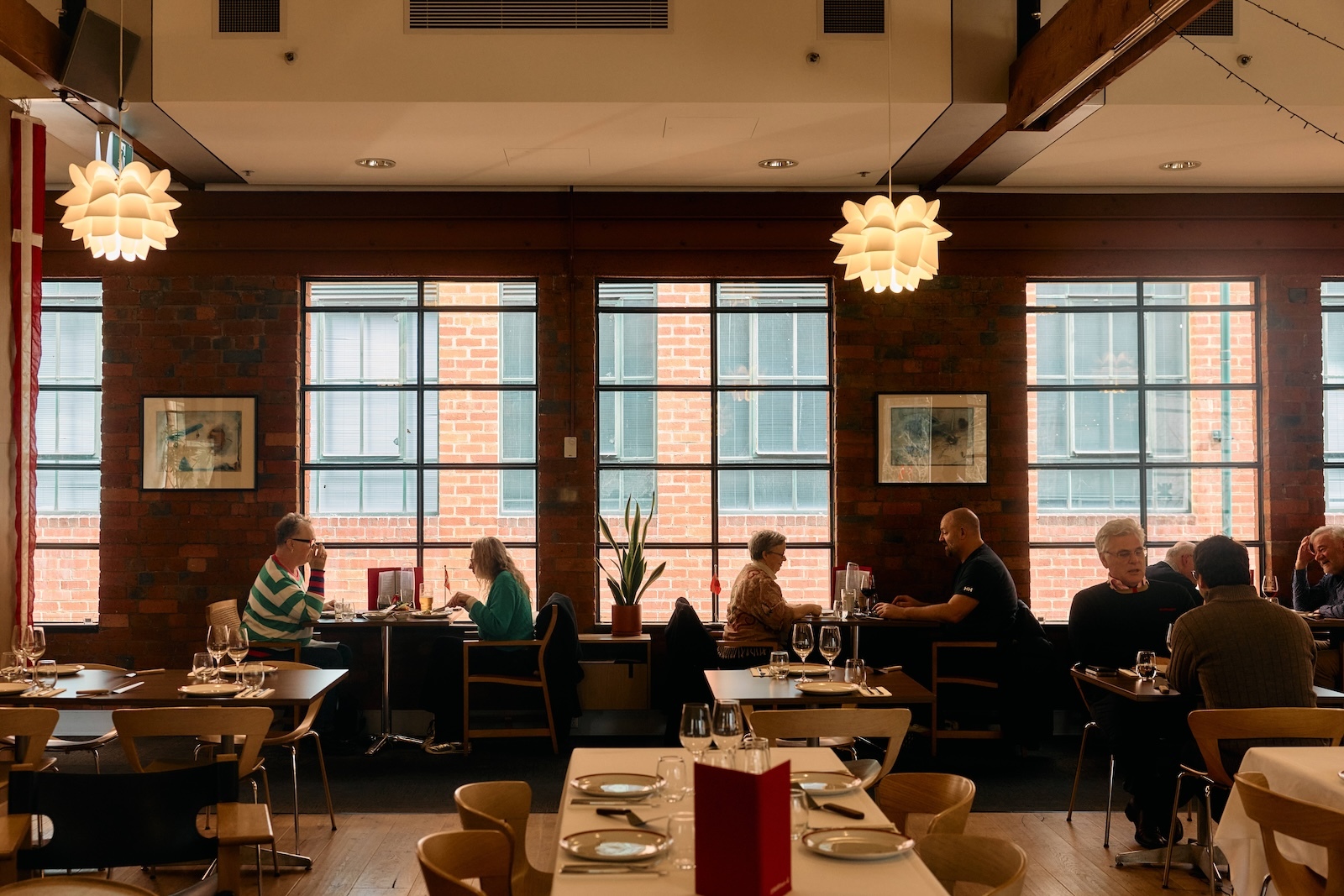 People eating by windows at a restaurant.