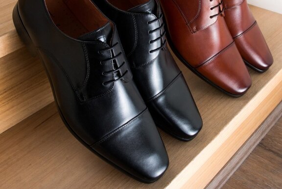 Pairs of men's shoes on wooden steps.