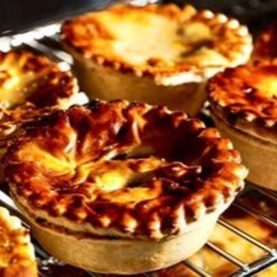 A tray of crispy pies on an oven shelf.