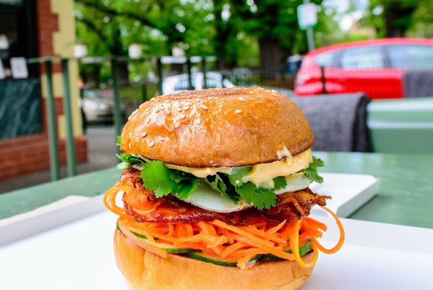 A breakfast roll with egg, coriander, carrot and cucumber.