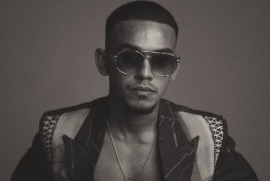 Performer wearing sunglasses and a patterned coat.