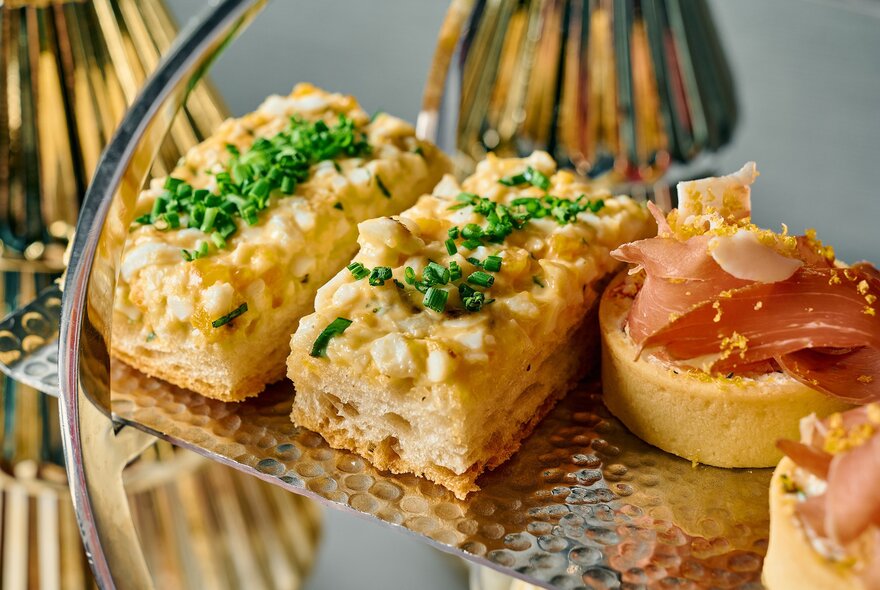 Savoury High Tea bites displayed on a hammered silver platter.