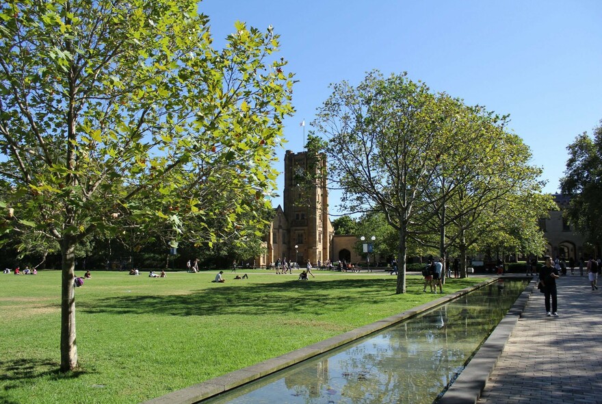 Students strolling the grassy grounds of the University of Melbourne.