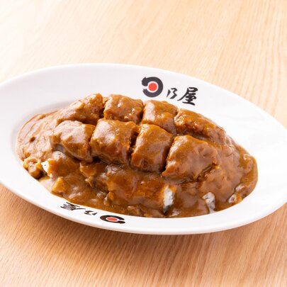 Japanese curry in a white bowl on a wooden surface.