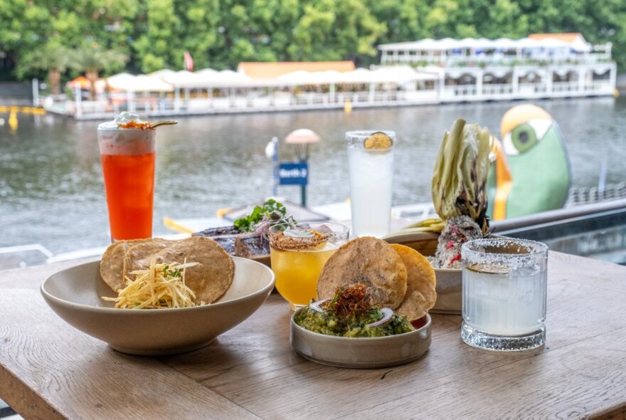 Mexican dishes and drinks on a table overlooking the Yarra River from Southbank.