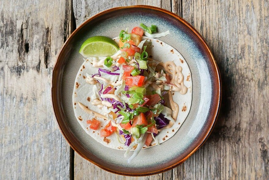 Tomato salad taco and a wedge of lime.