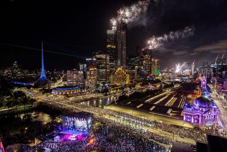 A view of Melbourne on New Year's Eve, with crowds of people enjoying the fireworks.