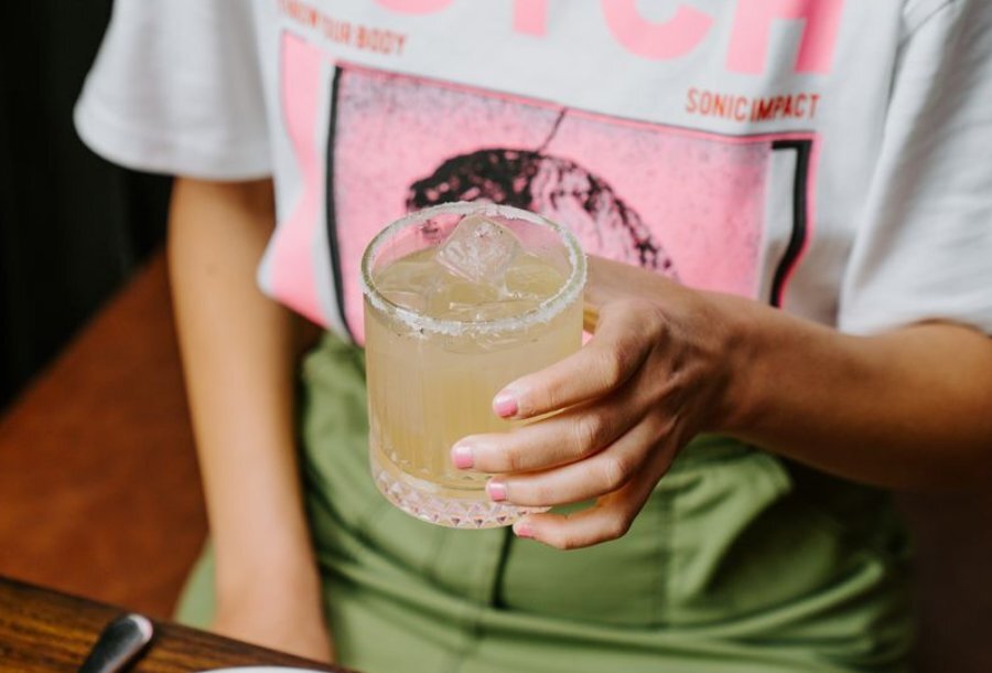 A woman's hand holding a margarita