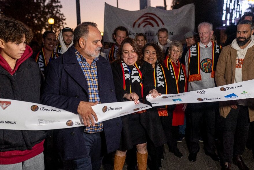 A line up of dignitaries and celebrities, including Michael Long, cutting a ceremonial ribbon.