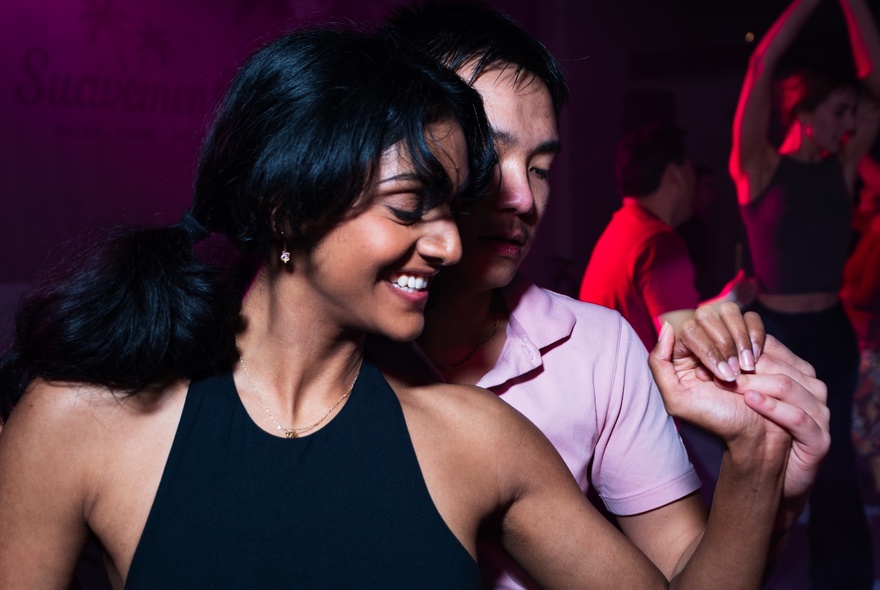 Male and female couple Latin dancing hand in hand.