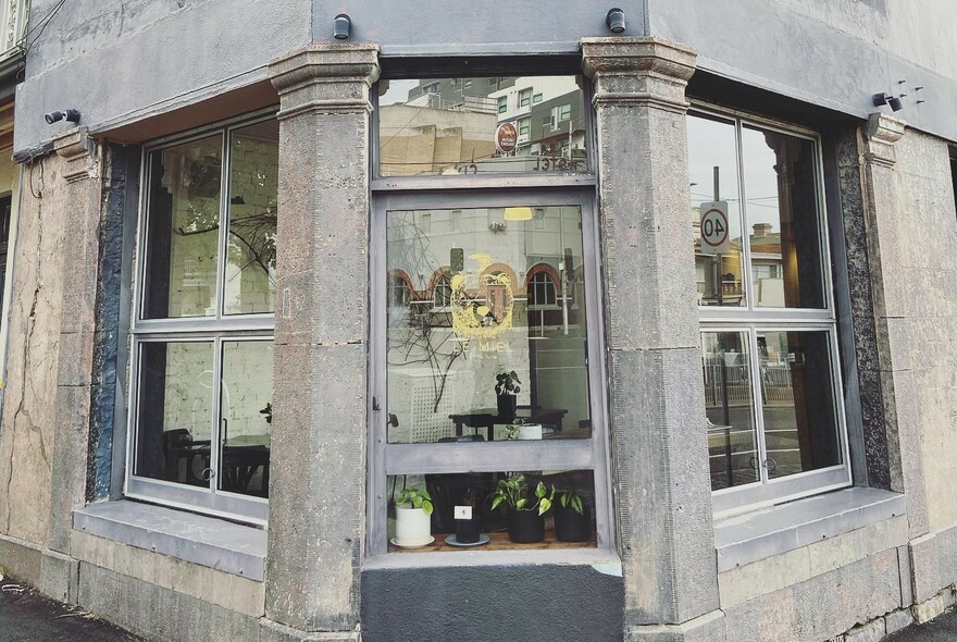 Cafe exterior, corner heritage building with Doric pillars framing windows.