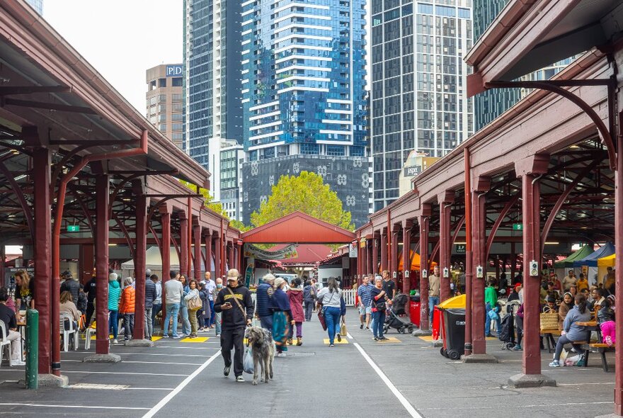 People walking between market sheds in the city.