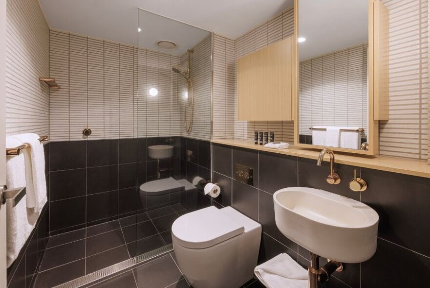 Hotel bathroom with white fittings and black and white tiling.