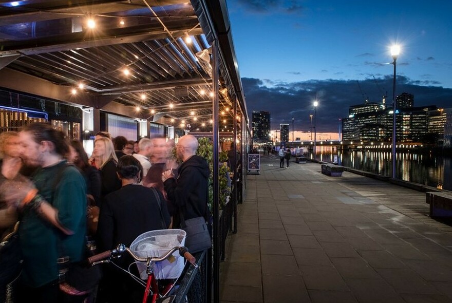 Outdoor tables at The General Assembly at night. 