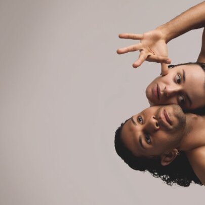 Dancers entwined, with woman's head appearing to be joined to a male dancer's shoulder.