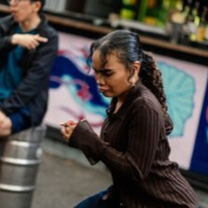 A street dance battle at Section 8 with a woman open-style dancing.