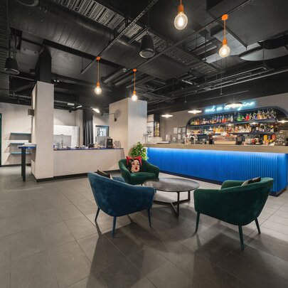A rudimentary hotel bar with a blue bar and small seating area.