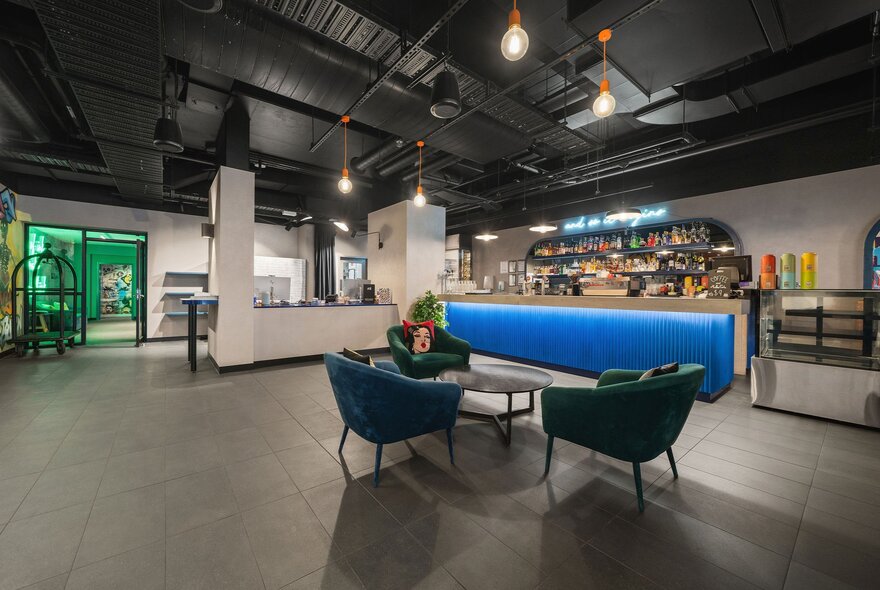 A rudimentary hotel bar with a blue bar and small seating area.