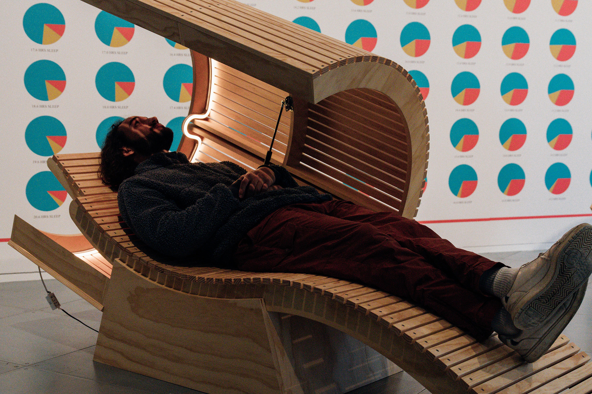 A person is lying down in a wooden sleep pod