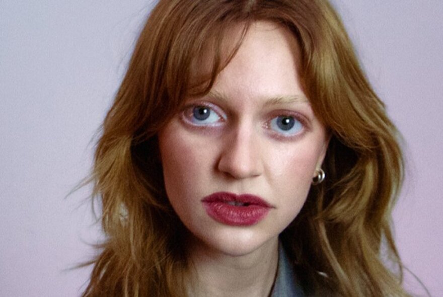 Woman with large red lips and big eyes with longish brown hair.