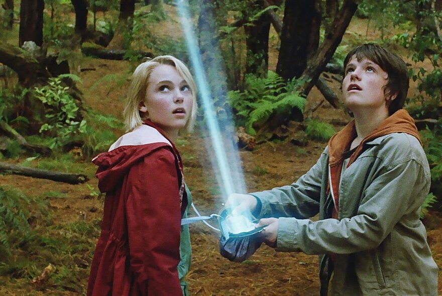Film still of two children holding a light sabre.