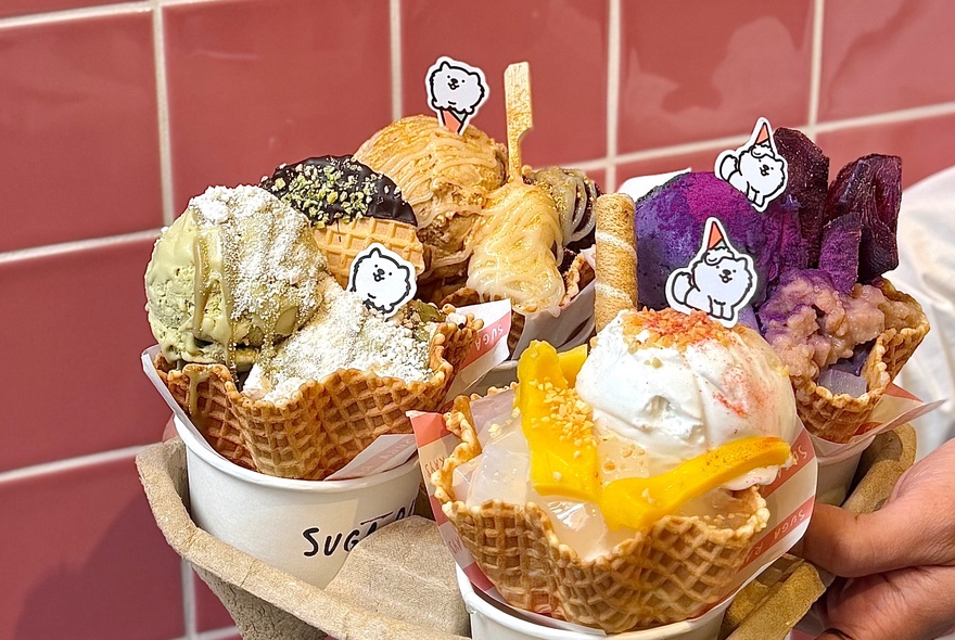 Four different ice-cream sundaes in a cardboard takeaway tray.