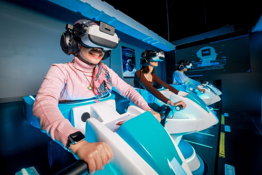 Children wearing VR goggles while driving game machines.