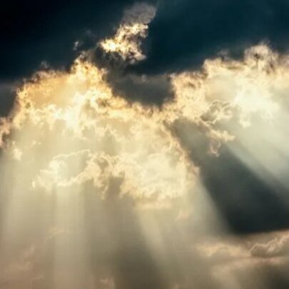Celestial sunlight pouring through dark clouds.