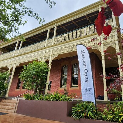 Exterior of a double-storey Victorian building with some plants out the front.