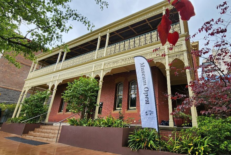Exterior of a double-storey Victorian building with some plants out the front.