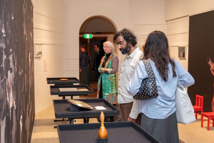 People inside Grainger Museum viewing an exhibition of percussive instruments on display stands.