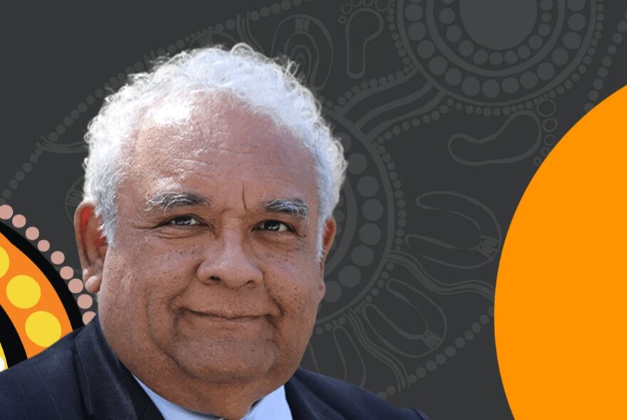 A smiling portrait of Professor Tom Calma AO, in front of a black and orange Indigenous design.