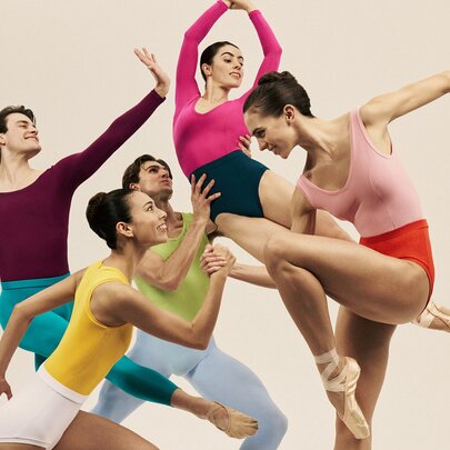 Dancers in different coloured leotards in different dance poses. .