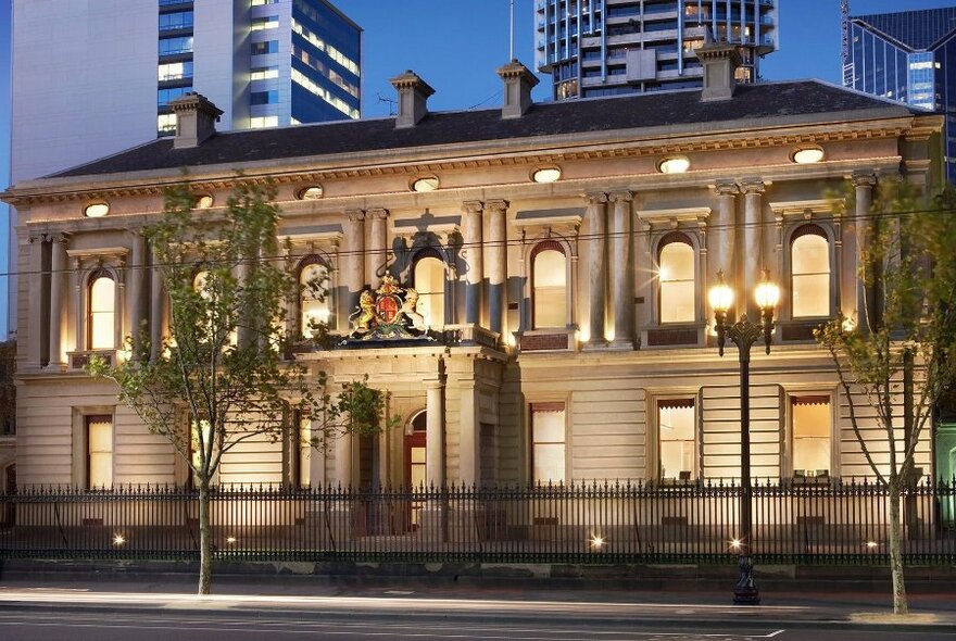 Exterior of Hellenic Museum at twilight, with city buildings visible in the background.