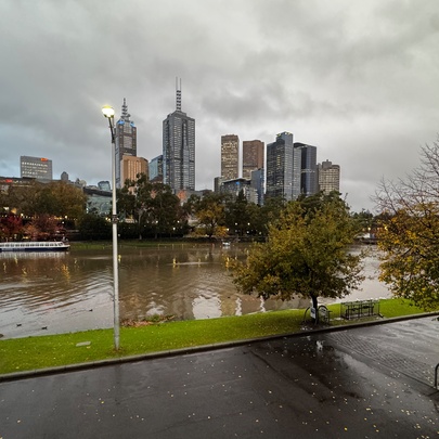 Wintry view of the Yarra River with city buildings and leafless trees against a grey sky.