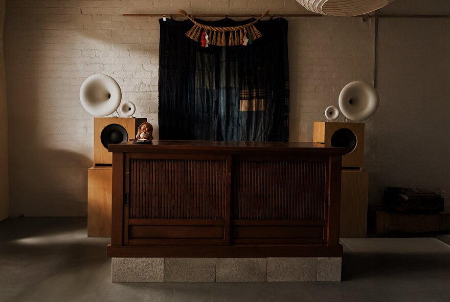 Wooden counter at Nordic Japan gallery, with speakers against a back wall.