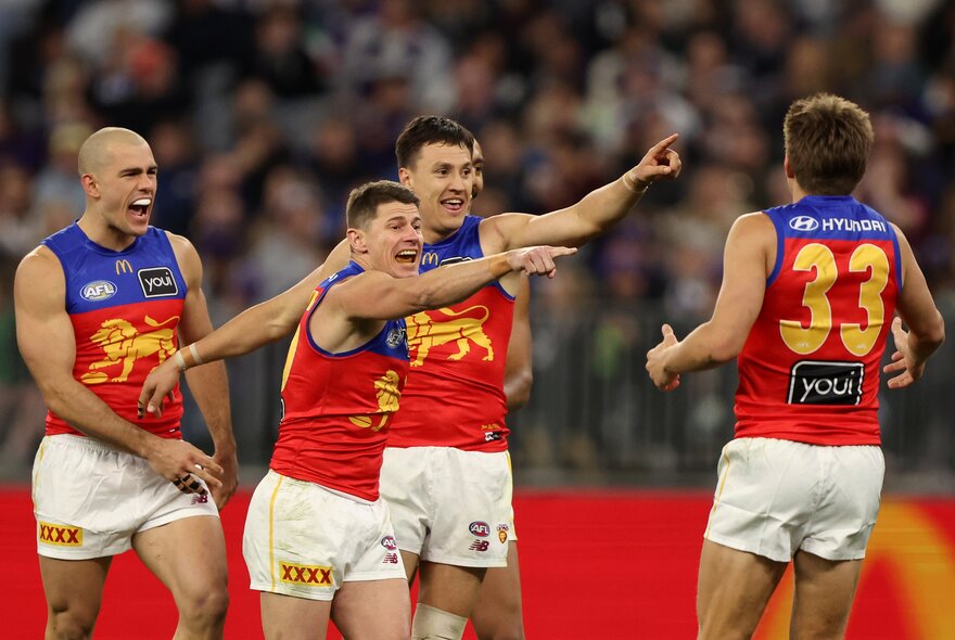 Brisbane Lions players sharing a fun moment during a match. 