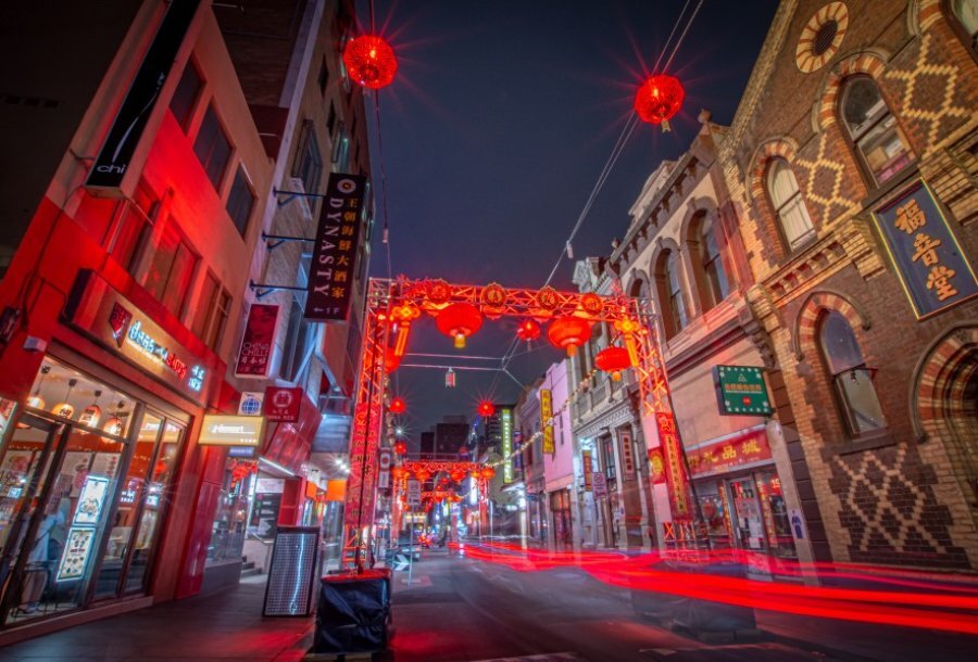 Melbourne's Chinatown at night with red lanterns and the glowing red lights of traffic.