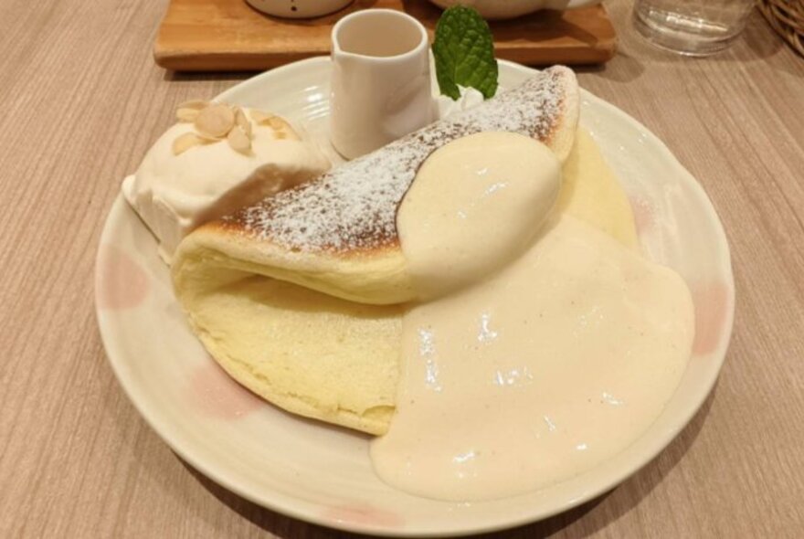 Souffle pancake with creamy sauce on a plate.